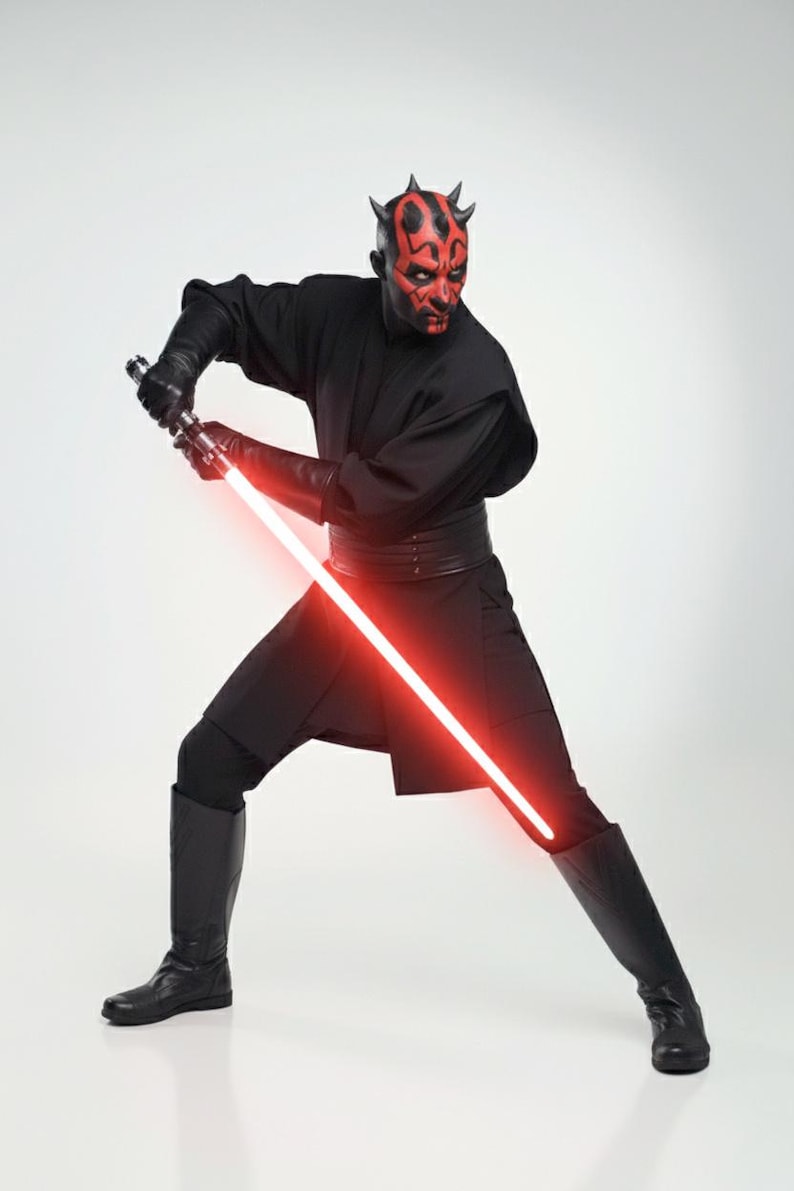 May include: A figure in a black outfit with a red and black face, wielding a red lightsaber. The costume comprises a black tunic, trousers, boots, and gloves. The lightsaber is illuminated, and the figure is in a combat pose.