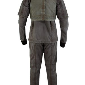 Puede incluir: Un uniforme completo de dos piezas en tonos grises y verde oliva. El conjunto incluye una chaqueta con una superposici&oacute;n tipo chaleco y pantalones a juego. La chaqueta tiene mangas largas con pu&ntilde;os negros. El uniforme parece estar hecho de una tela duradera.