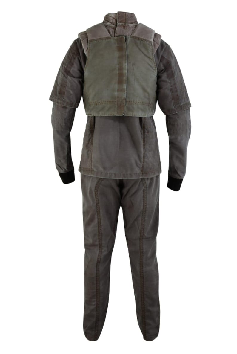 Puede incluir: Un uniforme completo de dos piezas en tonos grises y verde oliva. El conjunto incluye una chaqueta con una superposici&oacute;n tipo chaleco y pantalones a juego. La chaqueta tiene mangas largas con pu&ntilde;os negros. El uniforme parece estar hecho de una tela duradera.
