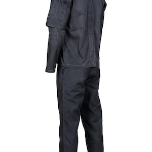 K&ouml;nnte beinhalten: Ein dunkelgrauer zweiteiliger Arbeitsanzug. Die Jacke hat einen hohen Kragen und Ziern&auml;hte an Schultern und &Auml;rmeln. Die Hose ist gerade geschnitten. Der Anzug ist aus strapazierf&auml;higem Stoff gefertigt.
