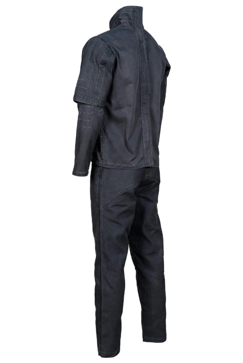 K&ouml;nnte beinhalten: Ein dunkelgrauer zweiteiliger Arbeitsanzug. Die Jacke hat einen hohen Kragen und Ziern&auml;hte an Schultern und &Auml;rmeln. Die Hose ist gerade geschnitten. Der Anzug ist aus strapazierf&auml;higem Stoff gefertigt.