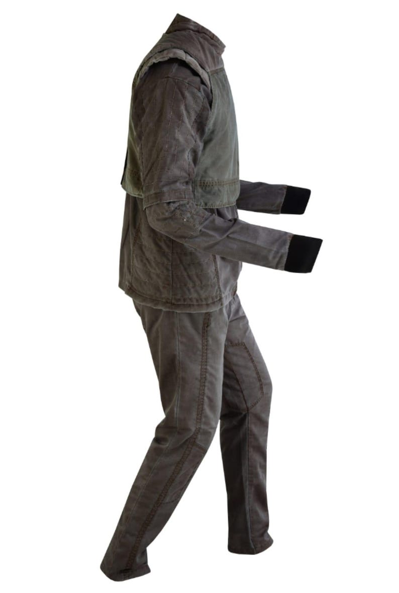 Puede incluir: Un conjunto de dos piezas gris-marr&oacute;n. La chaqueta tiene un cuello alto y una textura acolchada, con una pieza de hombro verde en contraste. Las mangas tienen pu&ntilde;os negros. Los pantalones son de color y estilo a juego, con costuras visibles.
