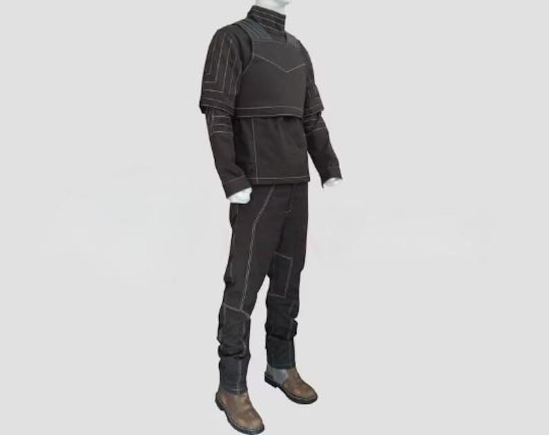 Pu&ograve; includere: Un completo tattico nero esposto su un manichino. L'outfit include una giacca a collo alto, un gilet e pantaloni, tutti con cuciture bianche. Gli stivali sono marroni e grigi.