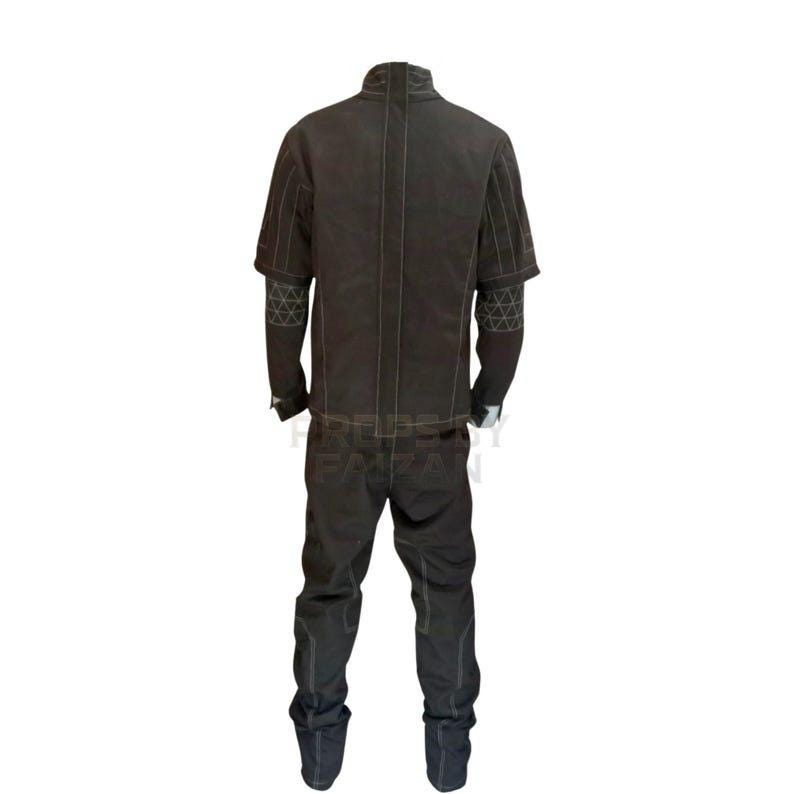 May include: A dark brown jumpsuit with a high collar and long sleeves. The sleeves have geometric patterns on the forearms. The pants are straight-legged, and the suit has visible stitching.
