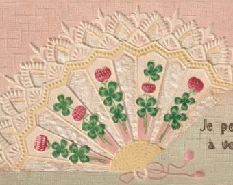 Postal antigua francesa en relieve, abanico de encaje decorado con flores y trébol de cuatro hojas, I Think About You, década de 1900