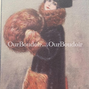 May include: A woman wearing a black coat with a fur collar and a black hat with a blue flower embellishment. She is holding a fur muff in her arms. The image has the text "Our Boudoir... Our Boudoir" printed on it.
