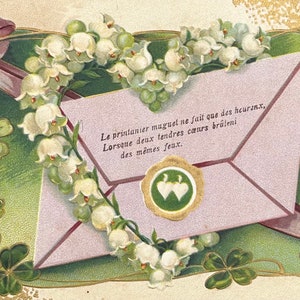 Embossed French Antique Postcard Featuring a Love Letter and a Heart of Lily of the Valley.  There are Good Luck Four Leaf Clovers Around th