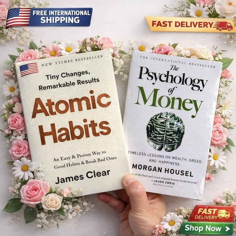 May include: Two hardcover books, "Atomic Habits" and "The Psychology of Money", are displayed with floral accents. "Atomic Habits" by James Clear, features brown text on a white cover. "The Psychology of Money" by Morgan Housel, has green text on a white cover.