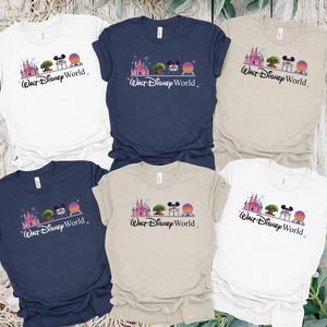 May include: Six t-shirts in various colors, including white, navy blue, and tan. Each shirt features a graphic of a castle, tree, Mickey Mouse, and a planet with the text "Walt Disney World" in a script font.