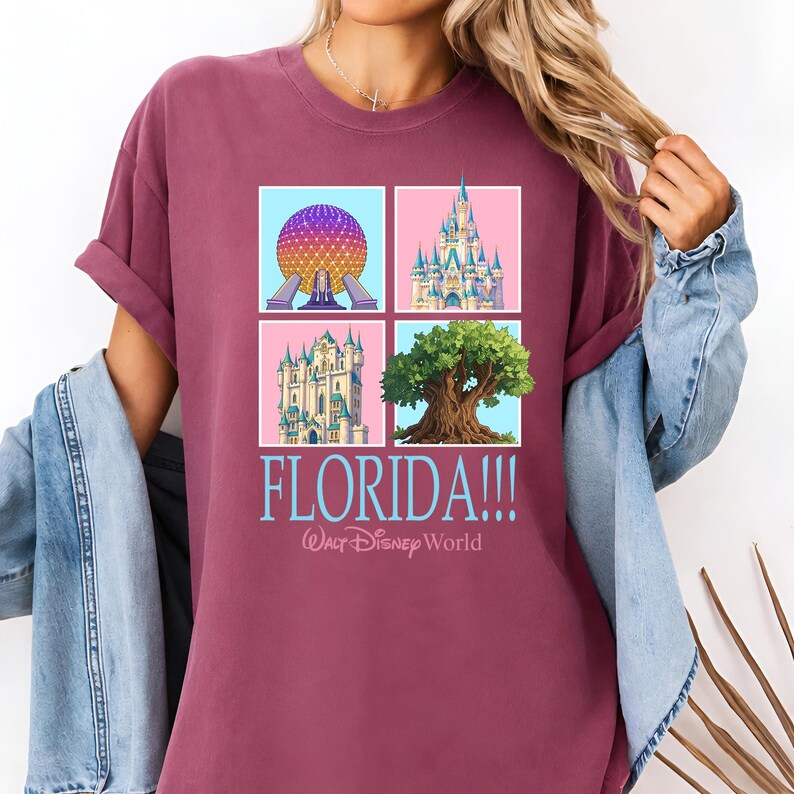 May include: Burgundy t-shirt featuring a four-square graphic with iconic Florida landmarks. The design includes a colorful sphere, a castle, a tree, and another castle, with the word "FLORIDA!!!" and "Walt Disney World" in light blue.