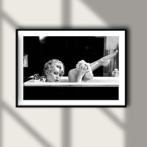 Puede incluir: Impresi&oacute;n enmarcada en blanco y negro que muestra a dos personas en una ba&ntilde;era. Una persona mira al espectador, la otra se lava con una esponja. La imagen es una fotograf&iacute;a de estilo vintage.