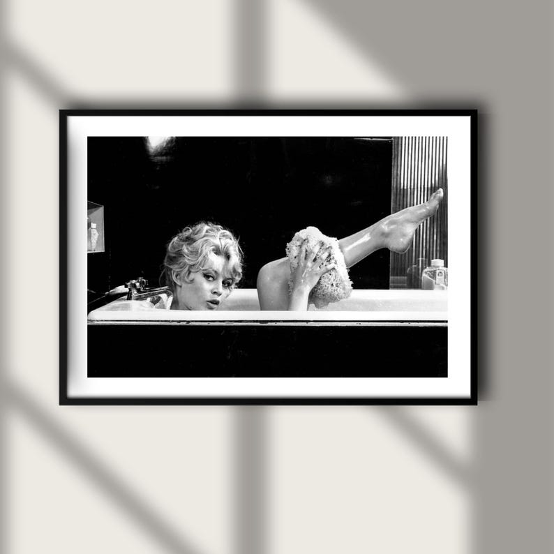 Puede incluir: Impresi&oacute;n enmarcada en blanco y negro que muestra a dos personas en una ba&ntilde;era. Una persona mira al espectador, la otra se lava con una esponja. La imagen es una fotograf&iacute;a de estilo vintage.