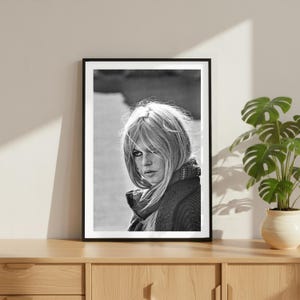 K&ouml;nnte beinhalten: Eine wei&szlig;e Keramiktasse mit schwarzem Henkel und dem Text "But First, Coffee" in schwarzer, fetter Schrift. Die Tasse steht auf einer wei&szlig;en Oberfl&auml;che. Die Tasse ist 10 cm hoch.