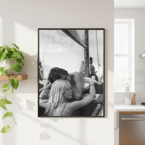 以下が含まれることがあります： 黒い持ち手と「But First, Coffee」のテキストが黒い太字で書かれた白いセラミックマグ。マグカップはぼやけた背景に置かれており、居心地の良い環境を示唆しています。