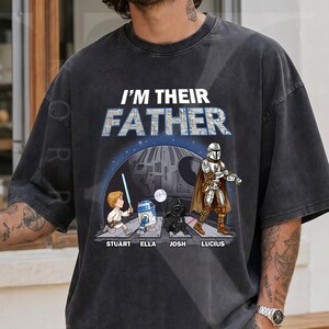 May include: Black graphic t-shirt with the text "I'M THEIR FATHER" above a Star Wars-themed illustration. The illustration features characters like Luke Skywalker, R2-D2, Darth Vader, and The Mandalorian, with names below.