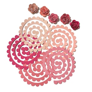 May include: A set of six paper flowers in shades of pink, with five smaller flowers and one large, layered flower with a spiral design.