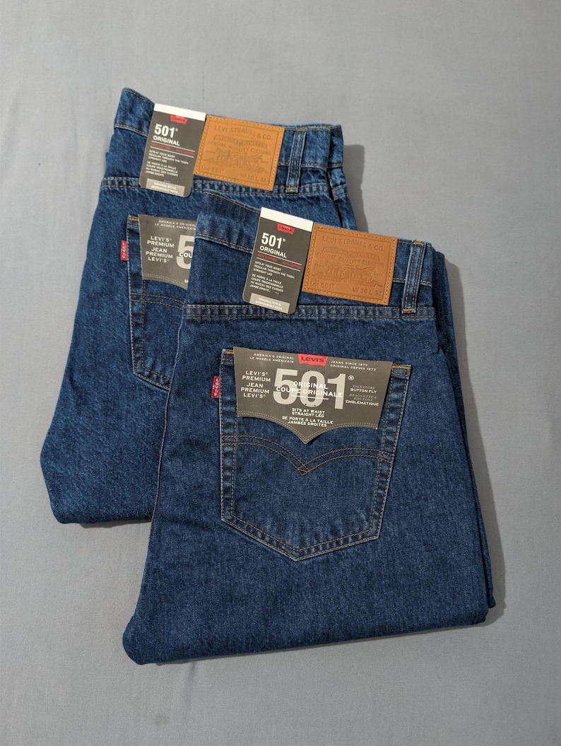 May include: Two pairs of blue denim jeans with tags. The jeans have a classic five-pocket design and a straight leg fit. The tags read "501 Original" and "Levi's Premium Collection". The jeans are folded neatly.