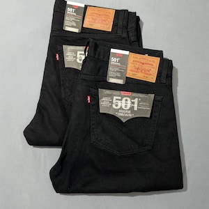 May include: A trio of cream-glazed ceramic mugs with a speckled finish. Each mug is adorned with a hand-painted design: a blue and green leaf, a yellow flower, and a red berry. The mugs have a simple, rounded form.