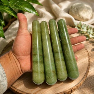 Puede incluir: Cuatro varitas cilíndricas hechas de piedra aventurina verde pulida. Cada varita presenta una parte superior lisa y redondeada y un cuerpo recto con inclusiones minerales naturales y variaciones en el color verde oliva intenso.