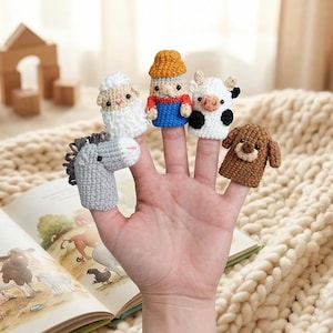 May include: A white ceramic mug with a black handle and the text "But First, Coffee" in a bold, black font. The mug is set against a blurred background, suggesting a cozy setting.