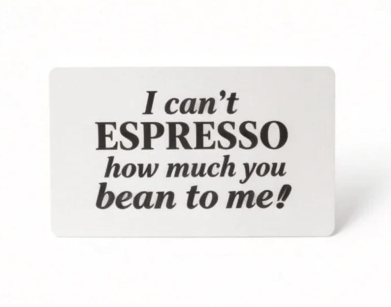 Puede incluir: Una tarjeta rectangular blanca con esquinas redondeadas presenta el texto "I can't ESPRESSO how much you bean to me!" en negro y negrita. La tarjeta est&aacute; sobre un fondo blanco liso.