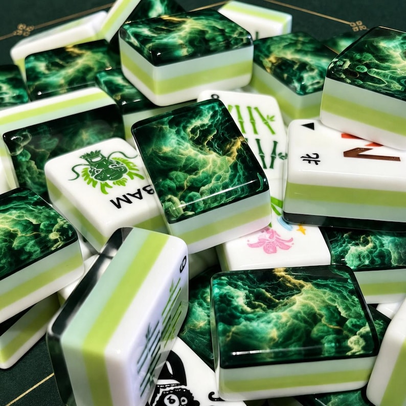 May include: A collection of mahjong tiles featuring a deep green and gold marbled pattern on the top surface, with white and light green layered sides. Some tiles display green dragon, bamboo, and floral symbols with black text markings.