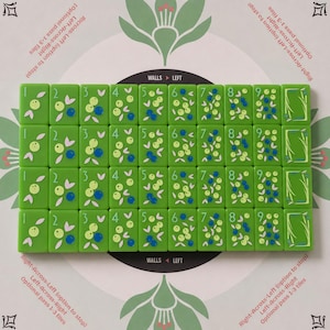 May include: A set of rectangular green tiles arranged in four rows, each featuring numbers one through nine and a decorative end tile. The tiles display illustrations of light green and blue berries with leaves. The text reads Walls Left.