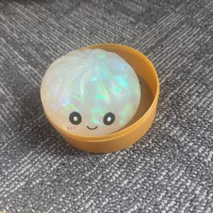 Kawaii Steamed Bun Squishy Toy in Glittery Pink, Green, Blue, or Gold – Served in Mini Steamer Basket for Calm & Joy