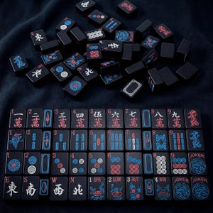K&ouml;nnte beinhalten: Ein Satz schwarzer Mahjong-Steine mit roten und blauen Markierungen. Die Steine liegen auf einer dunkelblauen Oberfl&auml;che. Das Set enth&auml;lt Steine mit chinesischen Schriftzeichen, Zahlen und Symbolen. Einige Steine haben Blumen- und Drachendesigns.