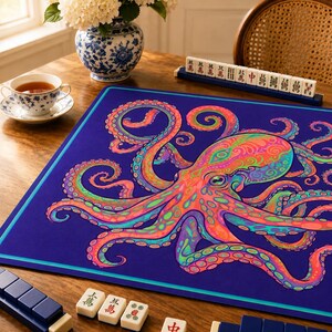 May include: A rectangular game mat featuring a vibrant, multi-colored octopus illustration with swirling tentacles in shades of pink, orange, green, and purple set against a deep blue background with a light blue border trim.