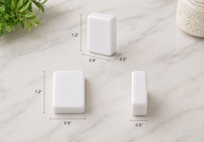 May include: Three white rectangular objects are displayed, each with rounded edges. The dimensions are provided: 1.2 inches in height, 0.9 inches in width, and 0.5 inches in depth. The objects are arranged on a light-colored surface.