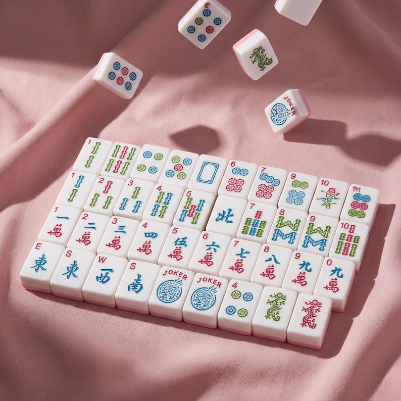 May include: A set of white and pink Mahjong tiles with various symbols and numbers, some in mid-air. The tiles feature Chinese characters, dots, and floral designs. The word "Joker" is visible on some tiles.