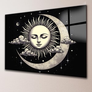 May include: A rectangular wall art piece featuring a central sun with a human face and closed eyes, surrounded by a large crescent moon. The design includes fluffy clouds, scattered stars, and a small crescent moon against a black background.