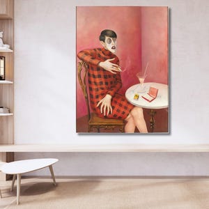 May include: A framed oil painting depicting a figure with dark hair and a pale face wearing a red and black plaid long-sleeved dress. The figure sits on a wooden chair at a round white table with a glass, a cigarette, and a small red box.