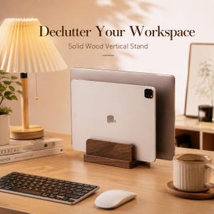 Puede incluir: Un soporte vertical de madera maciza sostiene un portátil y una tableta plateados. El soporte está sobre un escritorio de madera con un teclado, un ratón, una lámpara y una taza de café. Texto: "Declutter Your Workspace".