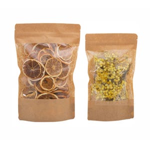 May include: Two kraft paper stand-up pouches with clear windows. One pouch contains dried orange slices, and the other contains yellow flowers. Both pouches have a zip-top closure and are set against a white background.