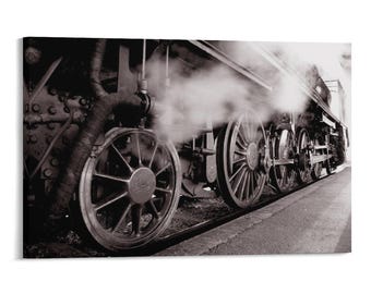 May include: A black and white photograph of a steam locomotive showing the large metal wheels and mechanical drive rods. Thick white steam billows from the engine, partially obscuring the intricate iron details of the train's undercarriage.