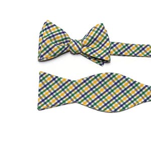 May include: A yellow, green, and blue plaid bow tie with a matching pocket square.