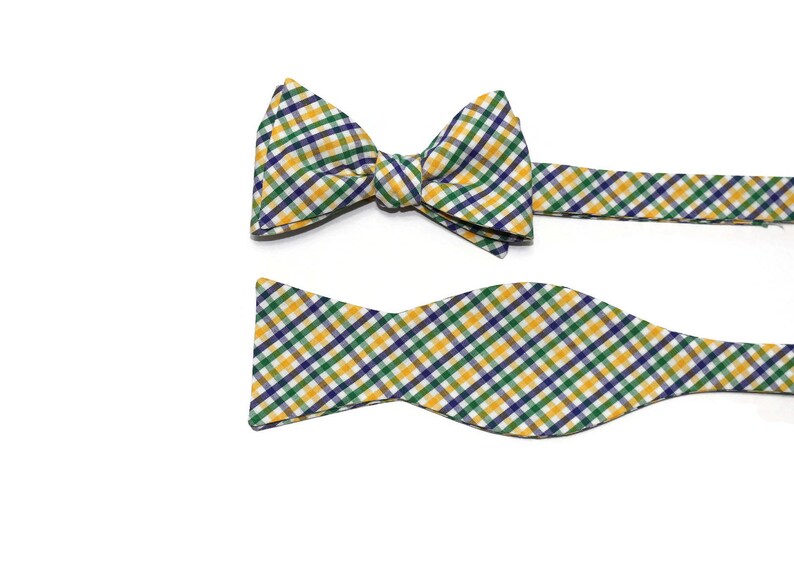 May include: A yellow, green, and blue plaid bow tie with a matching pocket square.