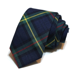 May include: A dark blue necktie with a green, yellow, and red plaid pattern.