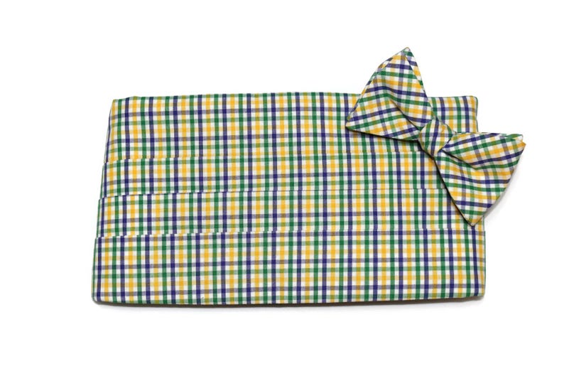 May include: A yellow, green, and purple plaid bow tie with a matching pocket square.
