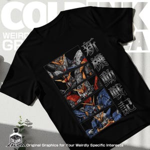 May include: A black short-sleeved t-shirt featuring a vertical graphic design of four stacked rectangular panels. Each panel displays a detailed illustration of a robotic mecha character in shades of blue, red, and yellow. Japanese text is printed vertically.