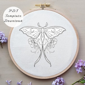 May include: A circular wooden embroidery hoop containing white fabric with a black line art illustration of a moth with long trailing wings and floral accents. The text PDF Template Download is printed in black on the upper left side.