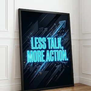 Puede incluir: Póster enmarcado en negro con el texto "LESS TALK, MORE ACTION" en neón azul brillante. El fondo es oscuro con flechas ascendentes y acentos de rayos. El póster está apoyado contra una pared blanca.