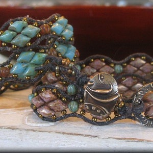 Op de afbeelding: Twee armbanden met turquoise en bruine kralen. De armband aan de linkerkant heeft een geweven ontwerp en de armband aan de rechterkant heeft een meer lineair ontwerp met twee metalen accenten.