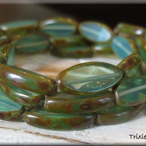 May include: A bracelet made of green and brown oval-shaped glass beads. The beads have a mottled, marbled effect.
