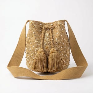 Peut inclure: Une tasse en céramique blanche avec une anse noire et le texte "But First, Coffee" en gras noir. La tasse est posée sur un fond flou, suggérant un cadre chaleureux.