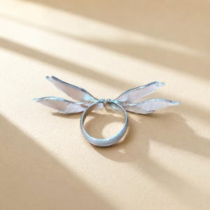 Silver angel wing enamel ring in natural light, showing the adjustable open design and wing details