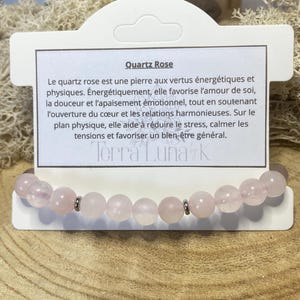 Peut inclure: Un bracelet composé de perles rondes en quartz rose pâle alternées avec de petites entretoises en métal argenté. Le bracelet est fixé sur un carton de présentation blanc portant le texte Quartz Rose et la marque Terra Luna K.