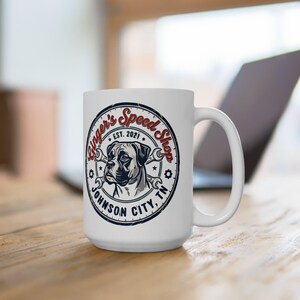 May include: White ceramic mug featuring a Boxer dog illustration within a circular design. The design includes the text "Ginger's Speed Shop EST. 2021" and "Johnson City, TN". The mug has a large handle and is set on a wooden surface.
